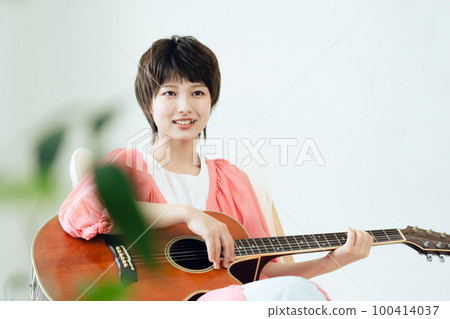 A young lady playing the guitar A young lady playing the guitar 100414037