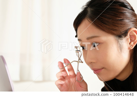 用睫毛夾卷睫毛的女人 100414648