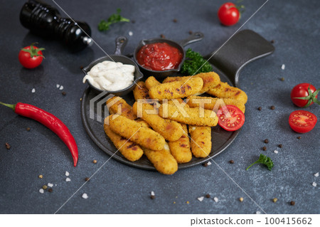 Cooked Mozzarella Cheese sticks with tartar and red tomato sauces on a plate 100415662
