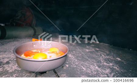 A guy cooks food on gas inside an ice cave. 100416696