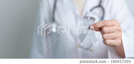 Brain Cancer Awareness May month, Doctor with grey color Ribbon for supporting life people. Healthcare and World cancer day concept 100417203