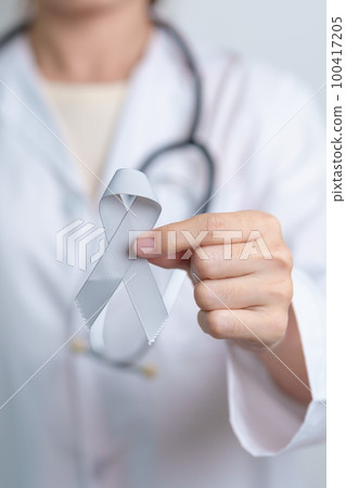 Brain Cancer Awareness May month, Doctor with grey color Ribbon for supporting life people. Healthcare and World cancer day concept 100417205