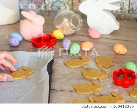 Womens hands close-up kneading ginger dough and carving figurines 100418350