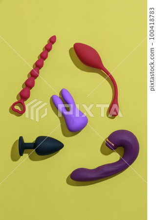 Top view of adult sex toys such as dildo, vibrator, buttplug on yellow background. Sex shop concept 100418783