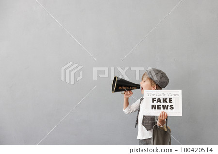 Newsboy shouting against grunge wall background. Boy selling fake news Newsboy shouting against grunge wall background. Boy selling fake news 100420514