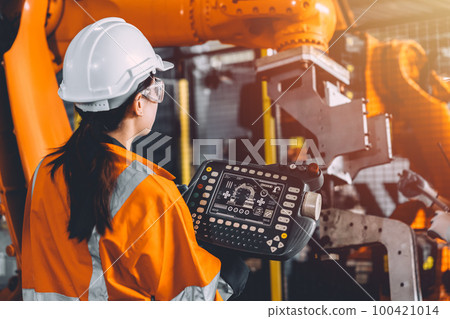 Engineer team service robot welding working in automation factory. Woman worker operate robotic arm software hand controller in automated manufacturing industry technology. Engineer team service robot welding working in automation factory. Woman worker operate robotic arm software hand controller in automated manufacturing industry technology. 100421014