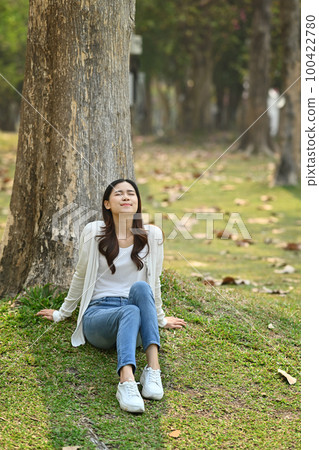 Portrait of happy young woman relaxing and breathing fresh air in summer park Portrait of happy young woman relaxing and breathing fresh air in summer park 100422780