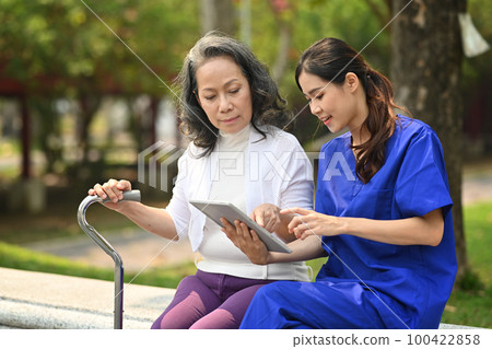 Female doctor in uniform instructing about treatment, giving consultation to elderly woman 100422858