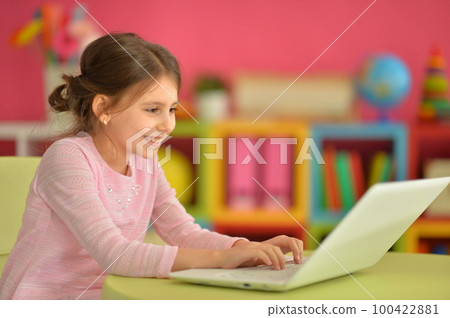 cute girl using laptop at home 100422881
