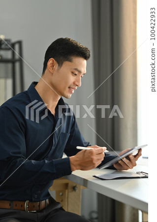 Portrait of millennial asian man using digital tablet for checking information or chatting online with client Portrait of millennial asian man using digital tablet for checking information or chatting online with client 100422933