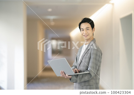 A businessman in his 30s looking at the camera with a laptop, photographed by LINK FOREST 100423304