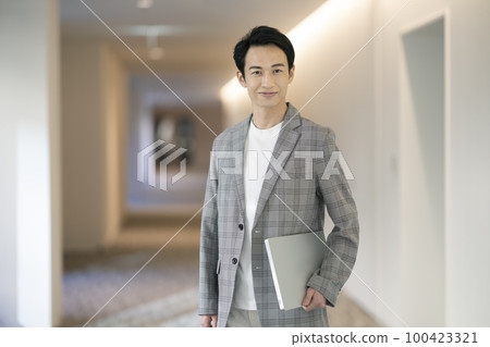 A businessman in his 30s looking at the camera with a laptop, photographed by LINK FOREST 100423321