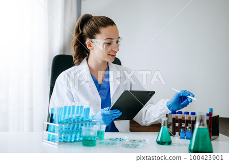 Female scientist researcher conducting an experiment in a laboratory... 100423901