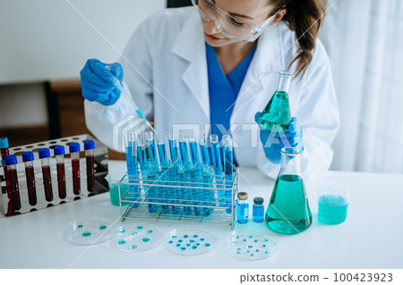 Scientist mixing chemical liquids in the chemistry lab. Researcher working in the chemical laboratory Scientist mixing chemical liquids in the chemistry lab. Researcher working in the chemical laboratory 100423923