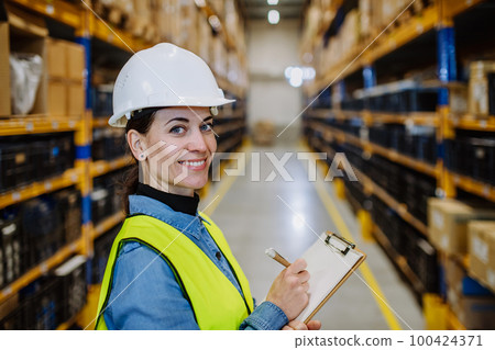 Warehouse female worker checking up stuff in a warehouse. 100424371