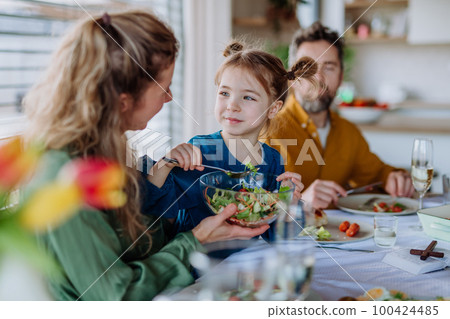Happy family having Easter dinner together in their home. 100424485