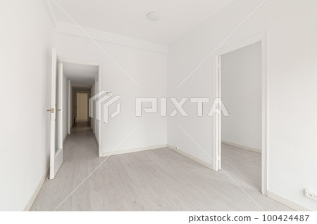 Empty spacious room with light walls and wooden laminate flooring with a corridor and access to another room. The concept of ready-to-let housing or a hotel room. Copyspace Empty spacious room with light walls and wooden laminate flooring with a corridor and access to another room. The concept of ready-to-let housing or a hotel room. Copyspace 100424487