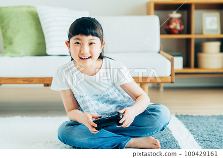 Elementary school girl playing games in the living room 100429161