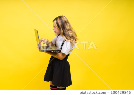 Little happy blonde kid girl 12-13 years laptop pc computer. Children lifestyle childhood concept. 100429846