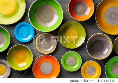 Color ceramic plates on gray background top view 100430158