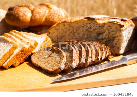 lot of different flavored bread, wheat, rye, on the table in the field outside lot of different flavored bread, wheat, rye, on the table in the field outside 100431943
