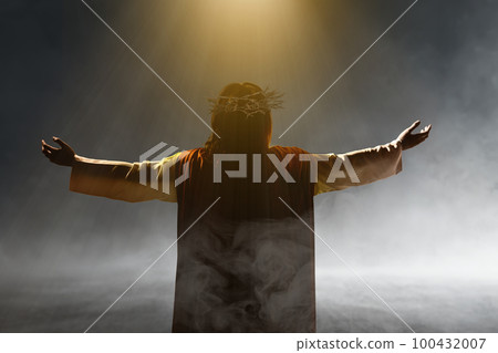 Rear view of Jesus Christ with a crown of thorns raised hands and praying to god 100432007