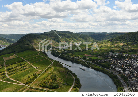 Bird's eye view of a village near the Moselle loop surrounded by greenery and vineyards in Germany 100432500
