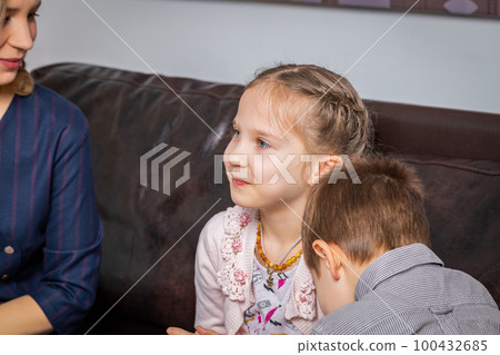 The girl answers the psychologist's questions at the reception. The girl answers the psychologist's questions at the reception. 100432685