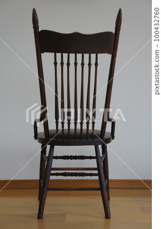 Dark colored antique dining chairs in a room with white walls and light wood flooring Dark colored antique dining chairs in a room with white walls and light wood flooring 100432760