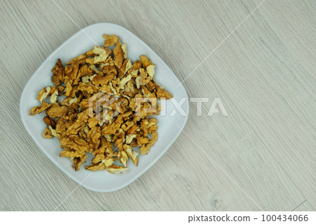 Walnuts in dish in wood background. Walnut kernels. Top view. 100434066