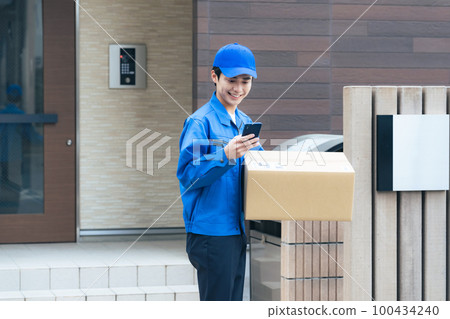 Worker holding a cardboard and using a smartphone Courier delivery staff Worker holding a cardboard and using a smartphone Courier delivery staff 100434240