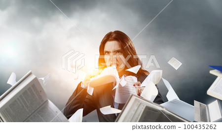 Young stressed woman ripping documents with frustrated facial expression. Young stressed woman ripping documents with frustrated facial expression. 100435262