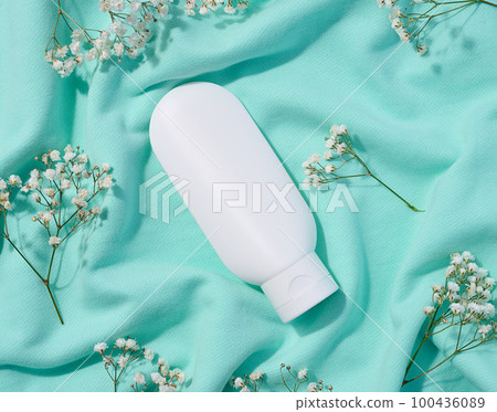 White plastic tube for cosmetics and sprigs of white gypsophila flowers, top view White plastic tube for cosmetics and sprigs of white gypsophila flowers, top view 100436089