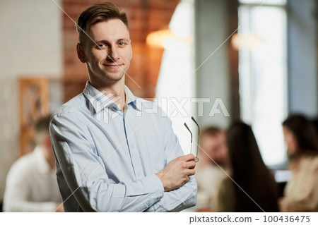 Employee of month. Motivated businessman in official clothes looking at camera. Employees having meeting at office. Blurred background 100436475