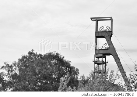 Grayscale shot of the winding tower of an old colliery in Essen, Ruhr area, NRW, Germany. Grayscale shot of the winding tower of an old colliery in Essen, Ruhr area, NRW, Germany. 100437808