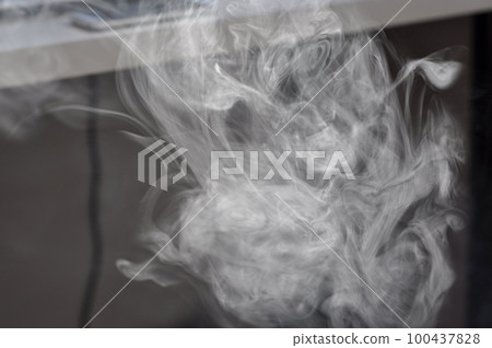 Smoke cloud of an e-cigarette in front of a desk Smoke cloud of an e-cigarette in front of a desk 100437828