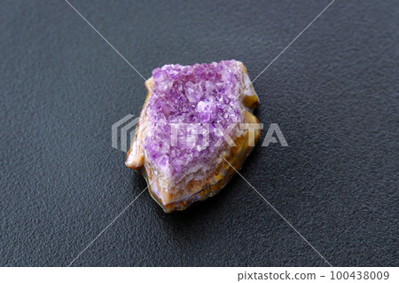 Crystal stone is a mineral. Purple rough amethyst quartz crystals, on black background 100438009