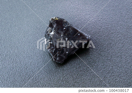 Black Obsidian stone on a black background. Natural glass. Black mineral gem 100438017