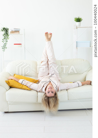 Fun minded woman wear pajama she sitting on couch use rest relax spend time in living room lounge home in own room hotel wake up Fun minded woman wear pajama she sitting on couch use rest relax spend time in living room lounge home in own room hotel wake up 100440024