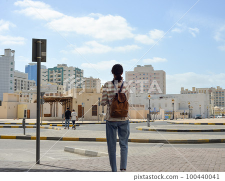 Woman tourist with a backpack on the Arab streets in the old part of Sharjah, UAE Woman tourist with a backpack on the Arab streets in the old part of Sharjah, UAE 100440041