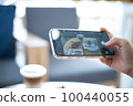 Woman taking a picture of food with a mobile phone in a cafe 100440055