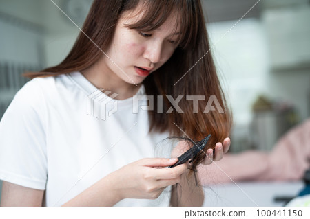 Asian woman have problem with long hair loss attach to comb brush. Asian woman have problem with long hair loss attach to comb brush. 100441150