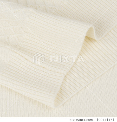 Knitted elastic band on creamy white wool jumper close up 100441571