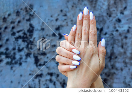 Female hands with a beautiful colored french manicure ombre white with blue. Female hands with a beautiful colored french manicure ombre white with blue. 100443302