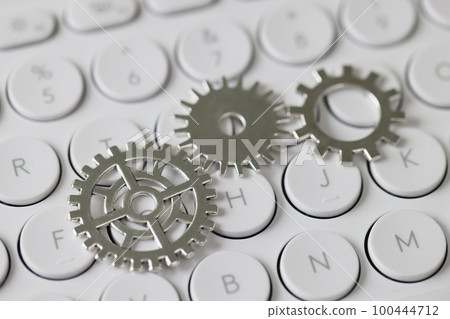 Connected cogwheels on white keyboard background. 100444712