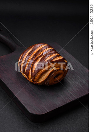 Delicious sweet crispy fresh baked cinnamon bun Delicious sweet crispy fresh baked cinnamon bun 100445226