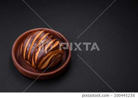 Delicious sweet crispy fresh baked cinnamon bun Delicious sweet crispy fresh baked cinnamon bun 100445238