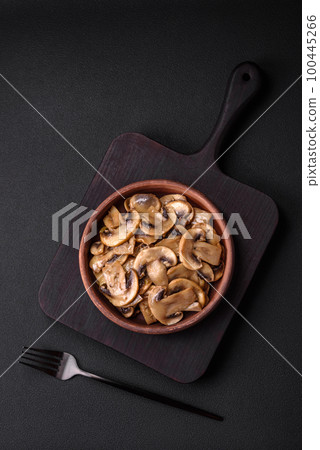 Fried or stewed champignon mushrooms in the form of slices with onions Fried or stewed champignon mushrooms in the form of slices with onions 100445266
