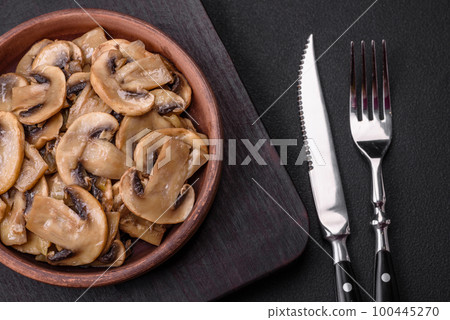 Fried or stewed champignon mushrooms in the form of slices with onions 100445270