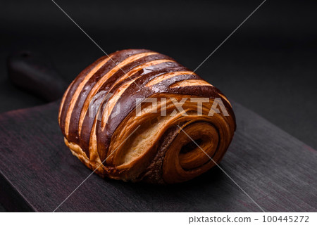 Delicious sweet crispy fresh baked cinnamon bun Delicious sweet crispy fresh baked cinnamon bun 100445272
